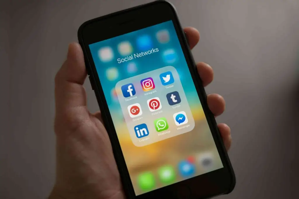 Digital Marketing's Absolute Necessity for Success in 2024 Unveiled | De Bie Media social media apps shown on a phone referring to the channels that you can use to apply digital marketing