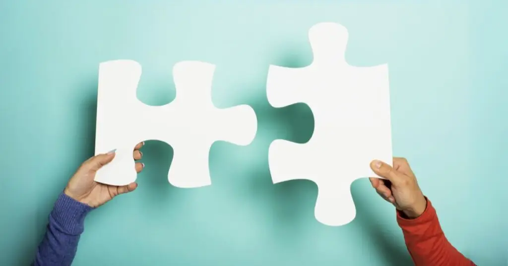 two arms each holding a puzzel piece that fit. This refers to the integration part in the Mailchimp vs Tinyemail comparison